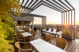 アスンシオンにあるHub Hotel Asuncionのバルコニーにテーブルと椅子があるレストラン