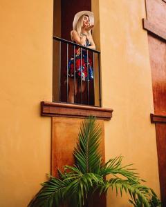 Una donna si trova su un balcone di Casa Sisal Valladolid Yuc a Valladolid