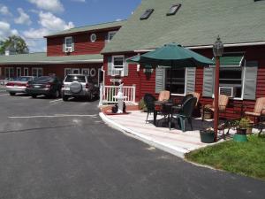 a patio with a table and an umbrella in front of a house at Midway Lodging in Cornish