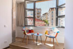 2 Stühle und ein Tisch vor einem Fenster in der Unterkunft Bravissimo Rambla Eiffel Bridge 1 in Girona