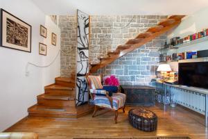 ein Wohnzimmer mit einer Treppe und einer Ziegelwand in der Unterkunft Mediterranean Villa with an Amazing View and a Pool by Loft in Piran