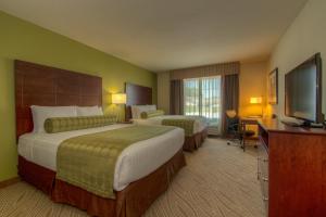a hotel room with two beds and a flat screen tv at Cobblestone Inn & Suites - Holyoke in Holyoke