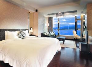 a hotel room with a bed and a large window at The Crystal Resort Sun Moon Lake in Yuchi