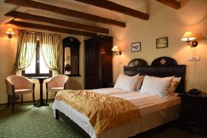 a bedroom with a bed and a desk and a window at Hotel Koronna in Timişoara