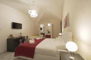 a bedroom with a large bed with a red blanket at Le Dimore del Duomo in Catania