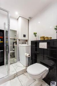 a white bathroom with a toilet and a shower at CMG Montorgueil V in Paris