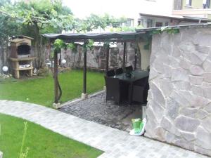 a backyard with a stone wall and a grill at Monteur-, Ferienwohnung mit Balkon in Hanau bei Frankfurt und Aschaffenburg in Hanau am Main