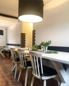 une salle à manger avec une table et des chaises blanches dans l'établissement Bed and Breakfast 33, à Ängelholm