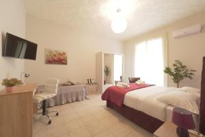 a bedroom with a bed and a desk and a television at Le Dimore del Duomo in Catania