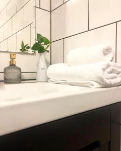 a white bathroom with towels on a sink at Bed and Breakfast 33 in Ängelholm