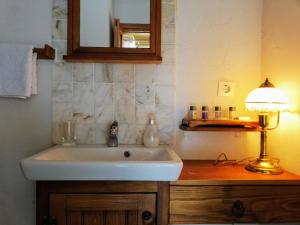 a bathroom with a sink and a lamp on a wooden counter at Ephesus Lodge in Kirazli