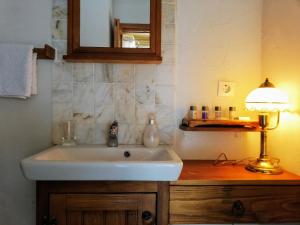 La salle de bains est pourvue d'un lavabo et d'une lampe sur un comptoir en bois. dans l'établissement Ephesus Lodge, à Kirazli