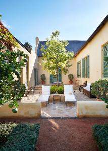 a patio with white chairs and a tree at Jonkmanshof - 20 Bath in Montagu