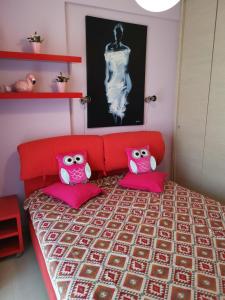 ein Schlafzimmer mit einem roten Bett mit rosa Kissen in der Unterkunft Purple_Rose_Apartment in Chaniotis