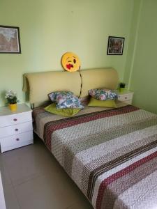ein Schlafzimmer mit einem Bett mit einem Smiley-Gesicht am Kopfteil in der Unterkunft Purple_Rose_Apartment in Chaniotis + 38 Fotos