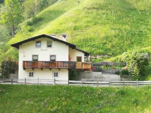 een huis met een balkon aan de zijkant van een heuvel bij Ferienhaus/Chalet in der Blaiche in San Leonardo in Passiria