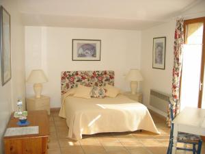 Un dormitorio con una cama y dos mesas y dos lámparas. en La Pacha, en Saint-Montan