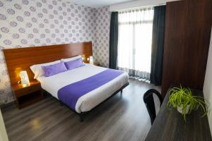 Un dormitorio con una cama grande con almohadas moradas. en Apartaments Atzavara, en Calella 37 fotos más