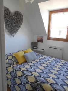 een slaapkamer met een bed met een hart aan de muur bij Cabourg Mathilde in Cabourg
