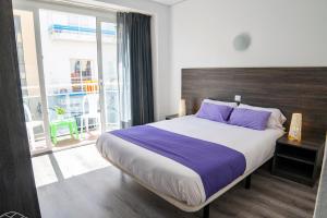Un dormitorio con una cama grande con almohadas moradas. en Apartaments Atzavara, en Calella