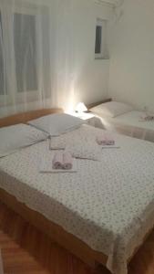 - une chambre avec 2 lits et des chaussons roses sur le lit dans l'établissement Tatijana Holiday Apartments, à Makarska