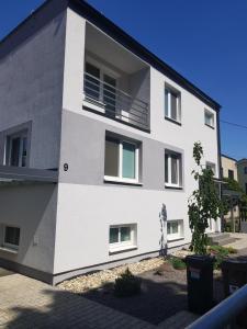 a white building with windows on the side of it at VIP Apartmány Žabník in Prievidza