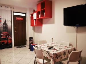 a dining room with a table with chairs and a tv at LONDON BY SEA in Porto Recanati