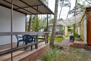 a porch with a picnic table and benches at Domki Blisko Morza in Niechorze