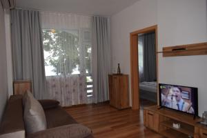 a living room with a couch and a flat screen tv at Ahilea Hotel - Free Pool Access in Balchik +68 photos
