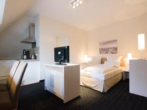 a hotel room with a bed and a flat screen tv at Nordsee Domizil Schobüll in Husum