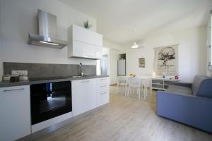 a kitchen with white cabinets and a living room at Corte della Cava in Favignana