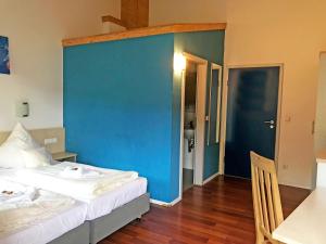 ネッカーズルムにあるBrau Art Hotelの青い壁のベッドルーム1室(ベッド1台付)