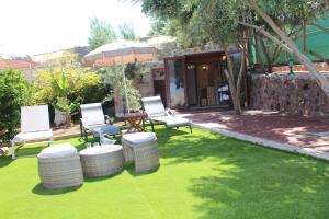 une cour avec des chaises, un parasol et de l'herbe dans l'établissement Villa Cantos Colorados, à Ingenio