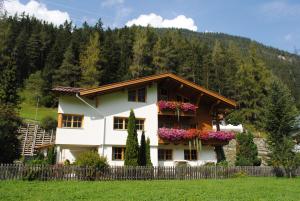una casa con cajas de flores a un lado. en Haus Untergand, en Sankt Anton am Arlberg