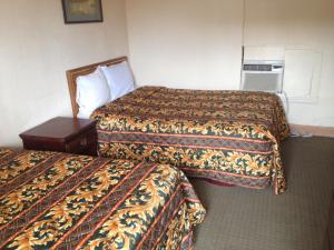 Habitación de hotel con 2 camas y mesita de noche en Beachtree Motel en Galveston