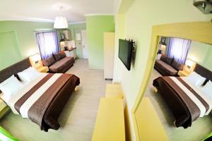 um quarto de hotel com duas camas e um sofá em Vliho Bay Suites & Apartments em Yénion
