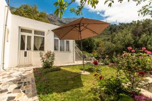 un jardín con sombrilla frente a una casa en Vacation Home Petar en Makarska