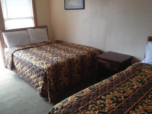 a hotel room with two beds and a table at Beachtree Motel in Galveston