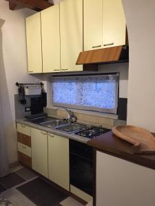 a kitchen with white cabinets and a stove top oven at LA CORTE DEL MULINO 1725 in San Salvatore Telesino