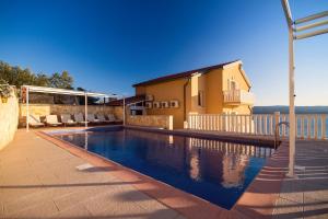 a swimming pool in front of a house at Villa Ana with private 50m2 pool, 7 bedrooms, 7 bathrooms, 18 persons max in Stanići