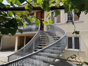 un escalier en colimaçon métallique menant à une maison dans l'établissement Shorena's House, à Zugdidi