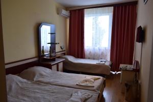 a hotel room with two beds and a window at Ahilea Hotel - Free Pool Access in Balchik
