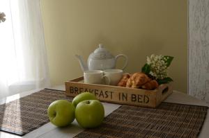 a tray with a breakfast in bed on a table with apples at Papli Villade Apartment in Pärnu +15 photos
