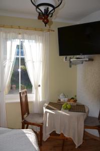 Pokój ze stołem z 2 krzesłami i oknem w obiekcie Papli Villade Apartment w Parnawie