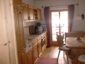 a kitchen with wooden cabinets and a table and a window at Schönfeldjoch in Bayrischzell