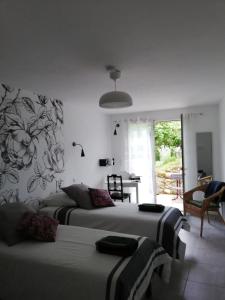 a bedroom with two beds and a living room at Les Perluètes in Carennac