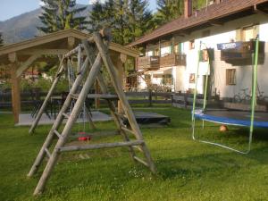 a wooden swing set in the yard of a house at Schönfeldjoch in Bayrischzell