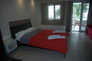 a bedroom with a bed with two towels on it at Studios Giannakis in Chrysi Ammoudia