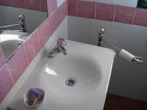 a white sink in a bathroom with a pink wall at Horta do Muro in Campo Maior +22 photos