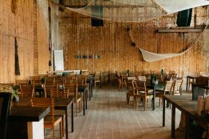 una sala da pranzo con tavoli e sedie in legno di Hotel Isbolaget a Donsö